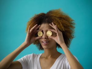 Girl holding crypto coins on her eyes