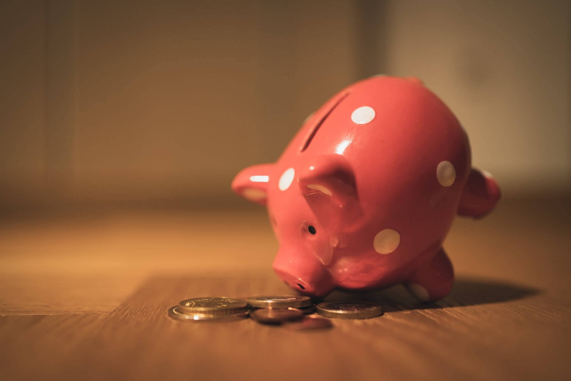 A picture of a Pink Piggy Bank with some coins in hd by Unsplash