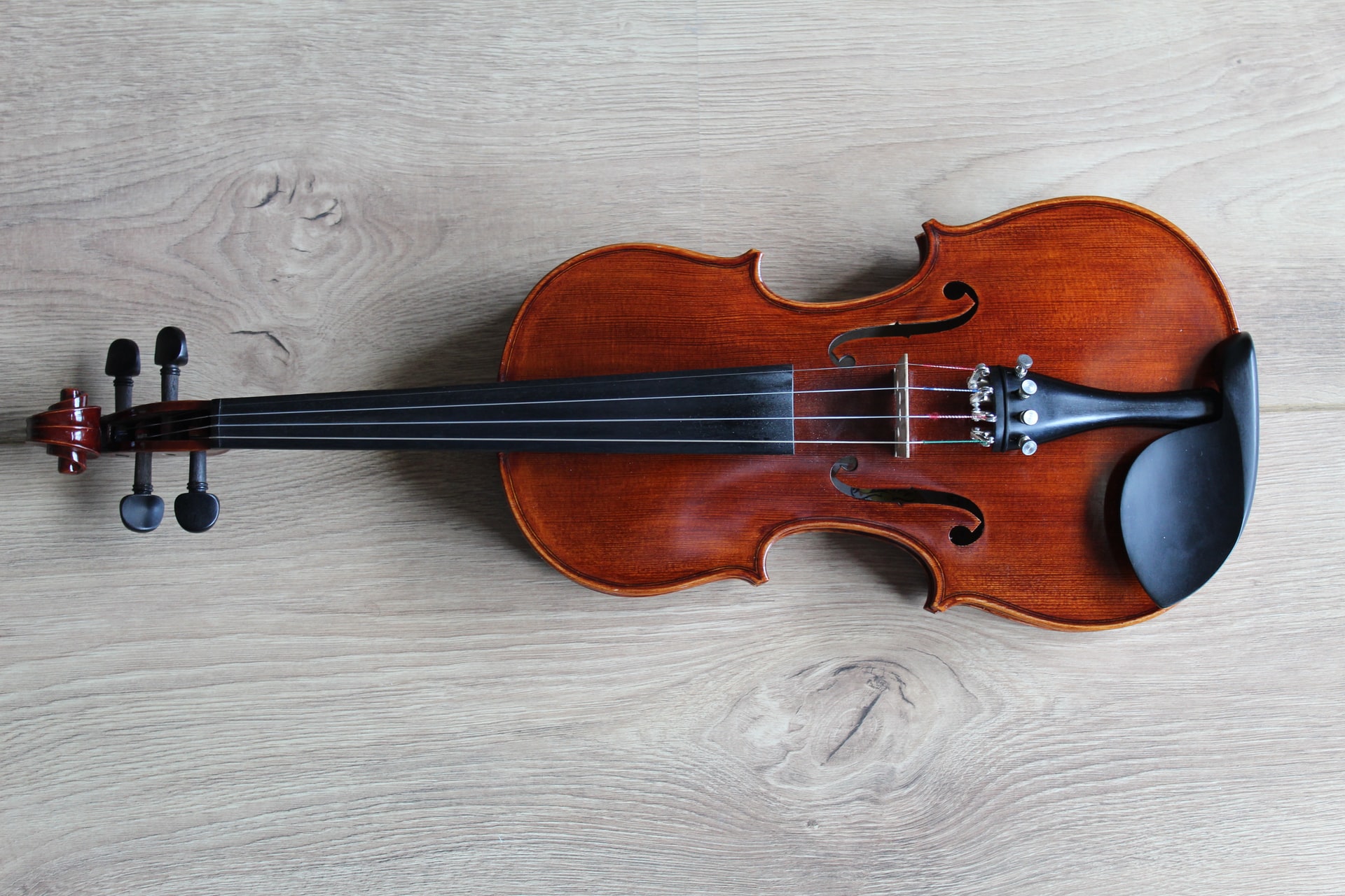 Hd Picture of a beautiful brown violin in a gray surface
