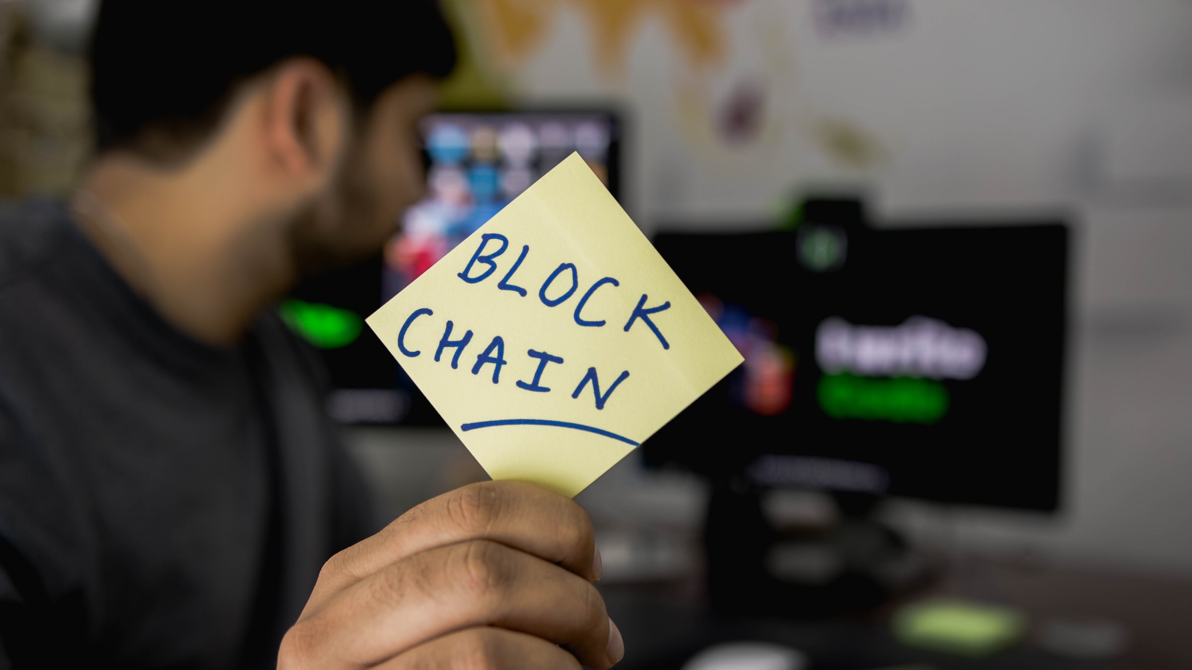 Picture of a person holding a paper written Block Chain on it